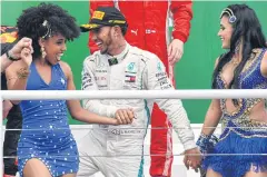  ?? AFP ?? Lewis Hamilton celebrates on the podium after winning the Brazilian Grand Prix.