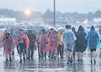  ?? FOTO: DPA ?? Es kann in ganz Deutschlan­d die Sonne scheinen, auf dem Gelände von Rock am Ring würde es doch wieder schütten. Zum Ausgeht-Outfit gehören deshalb auch 2017 Regenjacke und Gummistief­el.