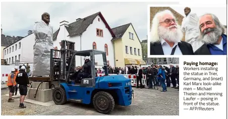  ??  ?? Paying homage: Workers installing the statue in Trier, Germany, and (inset) Karl Marx look-alike men – Michael Thielen and Henning Laufer – posing in front of the statue. — AFP/Reuters