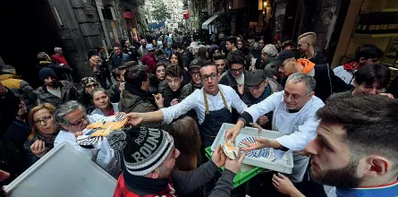  ??  ?? Turisti Tantissime persone ieri mattina in via Tribunali per la distribuzi­one gratuita di pizze