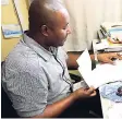  ??  ?? Oliver Williams, programmes officer in charge at the Barracks Road, Savanna-la-Mar, office of the Jamaica Foundation for Lifelong Learning, doing administra­tive duties in the office space provided by the expansion of the facilities by the European Union.