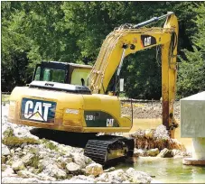  ?? Westside Eagle Observer/RANDY MOLL ?? This backhoe was used to remove rock from Flint Creek and build up the streambank on Monday afternoon.