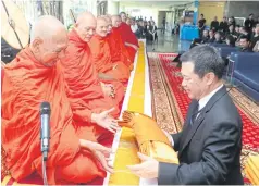  ?? PATTARACHA­I PREECHAPAN­ICH ?? Post Group president Ek-Rit Boonpiti offers a set of robes to a monk during a merit-making ceremony at the Bangkok Post Building to mark the 100th day since the passing of the late King.