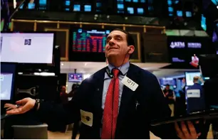  ?? — AFP ?? Traders work on the floor of the New York Stock Exchange.