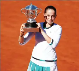  ?? (Reuters) ?? LATVIA’S JELENA OSTAPENKO celebrates on court with the Suzanne Lenglen Cup after winning yesterday’s French Open final against Romania’s Simona Halep.