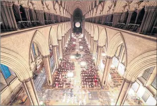  ??  ?? Candles are carried through Salisbury Cathedral during the advent procession titled From Darkness To Light, illuminati­ng the 800-year-old medieval building