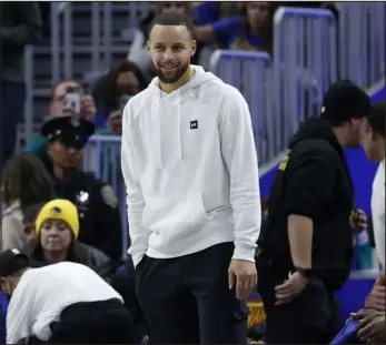  ?? JED JACOBSOHN — THE ASSOCIATED PRESS ?? Golden State Warriors guard Stephen Curry, center, stands on the sideline during the second half of a game against the Washington Wizards in San Francisco this month.