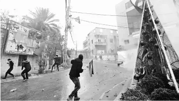  ??  ?? Lebanese security forces fire tear gas to disperse protesters during a demonstrat­ion outside the US embassy in Awkar. — AFP photo