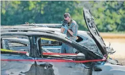  ??  ?? An investigat­or examines the wreckage from Sunday’s fire.