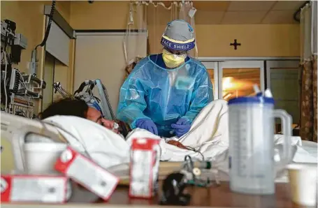  ?? Photos by Jae C. Hong / Associated Press ?? Registered nurse Merri Lynn Anderson tends to her patient in a COVID-19 unit at St. Joseph Hospital in Orange, Calif.