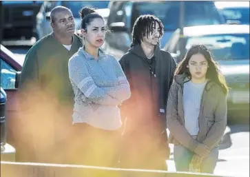  ?? Irfan Khan Los Angeles Times ?? SOME of the residents displaced by a fire at a three-story apartment complex in Pico Rivera wait for arson investigat­ors to finish their work at the building in the 9000 block of Burke Street. Dozens of units burned.