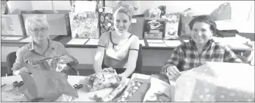  ?? MATTHEW MCCCULLY/RECORD ARCHIVES ?? Volunteer Jo-anne Anderson, administra­tive assistant Kayla Dempsey and LDWC board president Louise Caron, wrapping gifts that will be distribute­d to the sponsor families before Christmas during the 2016 Secret Santa campaign.