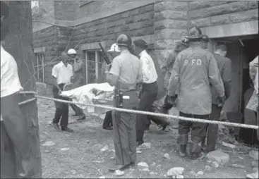 ?? ASSOCIATED PRESS FILE ?? In this Sept. 15, 1963 photo, firefighte­rs and ambulance attendants remove a covered body from the 16th Street Baptist Church in Birmingham, Ala., after by a deadly explosion detonated by members of the Ku Klux Klan during services. The 2018 mail-bomb scare has reopened old wounds for Lisa McNair, whose life has been shaped by the blast that occurred a year before she was born, killing her sister, Denise, 11. “It’s like, ‘Ugh, again.’ When are we going to get this right?” asked McNair. “It’s been 55 years since Denise was killed. Why do we keep going there in America? Why do we keep going there as a world and human beings?”
