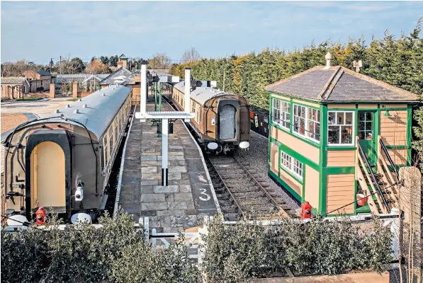  ??  ?? Michael Attle’s garden, where he has constructe­d a 1920s railway station, with restaurant carriages; the one to the left is named after Lord Mountbatte­n. Above right, Mr Attle (right) with Alex Adomeit, restaurant manager