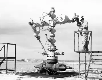  ?? — Reuters photo ?? File photo shows a worker measuring the pressure and temperatur­e of an oil and gas production tree in the Loma Campana Vaca Muerta shale oil and gas drilling site, in the Patagonian province of Neuquen.