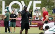  ?? STEVE HELBER — THE ASSOCIATED PRESS ?? New York Jets head coach, Todd Bowles, center talks with quarterbac­k Josh McCown (15) during the New York Jets Washington Redskins NFL football training camp in Richmond, Va., Monday.