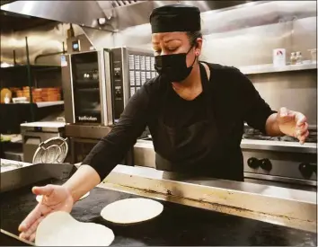  ?? Brian A. Pounds / Hearst Connecticu­t Media ?? A cook prepares tortillas in February at the new VivaZ Cantina Mexican restaurant in New Haven. The hospitalit­y sector led all in Connecticu­t in contributi­ons to economic growth in the fourth quarter of 2021, helping boost the state to the top 12 nationally for total growth.