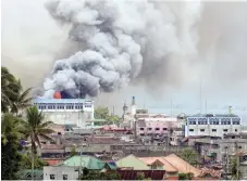  ??  ?? Black smoke comes from a burning building in a commercial area of Marawi city.