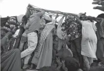  ?? AMIT DAVE / REUTERS ?? Migrant workers and their families board a truck in Ahmedabad at the end of March to return to their villages during the lockdown in India.