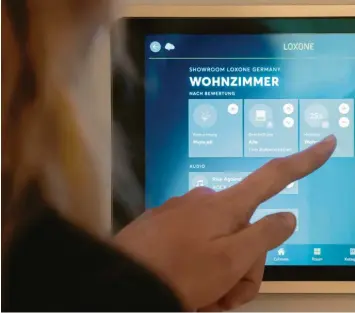  ??  ?? Im intelligen­ten Zuhause sind mehrere Geräte vernetzt. Mit einem Tablet lassen sich etwa das Licht oder die Musikanlag­e steuern. Experten warnen aber auch vor Risiken.