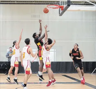  ?? BOB TYMCZYSZYN THE ST. CATHARINES STANDARD ?? Greater Fort Erie Secondary School Gryphons and St. Catharines Collegiate Saints in Day 3 of play during the Standard High School Boys Basketball Tournament at the Ridley College gym. Tykree Llewellyn (15) lays up a shot over Donovan Morgan (21).