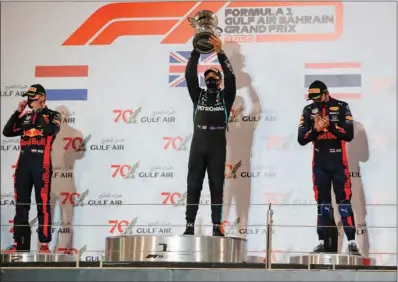  ?? (AFP) ?? Mercedes’ British driver Lewis Hamilton lift’s the winner’s trophy on the podium after the Bahrain F1 GP in the city of Sakhir on Sunday,