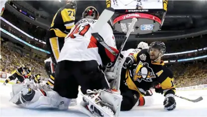  ??  ?? PITTSBURGH: Chris Kunitz #14 of the Pittsburgh Penguins falls to the ice in front of the net against Craig Anderson #41 of the Ottawa Senators during the third period in Game One of the Eastern Conference Final during the 2017 NHL Stanley Cup Playoffs...