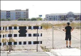  ?? STEVE MARCUS ?? Las Vegas Sun reporter Adam Candee looks at the Raiders Stadium site from Aldebaran Avenue.