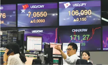  ?? Jung Yeon-je / AFP / Getty Images ?? Currency dealers monitor exchange rates in a trading room at the KEB Hana Bank in Seoul. The Chinese currency steadied a day after Beijing let the yuan weaken against the dollar, sending markets into freefall.