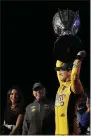  ?? LUIS M. ALVAREZ ?? Kyle Busch, right, holds up his trophy in Victory Lane after winning a NASCAR Cup Series auto racing season championsh­ip at Homestead-Miami Speedway in Homestead, Fla., Sunday.