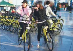  ?? KONG GE / FOR CHINA DAILY ?? Two girls get ready to ride Ofo bicycles in Tianjin.