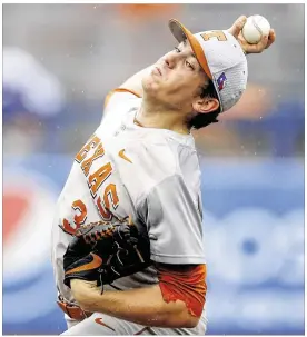  ?? SUE OGROCKI / AP ?? Starting pitcher Kyle Johnston shakes offff the wet weather Sunday to retire 14 batters in a row before giving up a run in the sixth inning in Texas’ championsh­ip win.