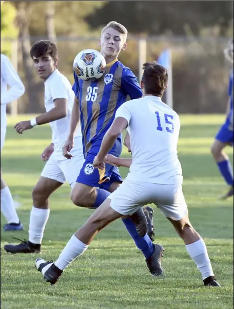  ?? Photo by John Zwez ?? St. Marys Memorial’s Cody Birth reacts as the ball bounces off his chest against Defiance’s Logan Hartman during an OHSAA Division II Boys Soccer Sectional Tournament semifinal match Monday at Roughrider Field.