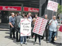  ?? GAVIN YOUNG/ CALGARY HERALD ?? Pro-energy industry demonstrat­ors protest outside the Tim Hortons at 4 St. SW and 11 Ave. at lunchtime Friday.