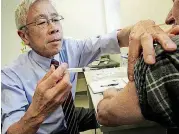  ?? [AP FILE PHOTO] ?? Dr. Harry Chen gives a whooping cough vaccine in 2012 in Barre, Vermont.
