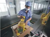  ?? Reuters ?? A worker packs oil made from imported US soybeans at a factory in Shandong Province, China