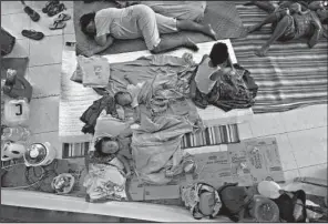  ?? AP/ERWIN MASCARINAS ?? People rest Saturday at a shelter in the provincial capital, Suriago, in the central Philippine­s as Typhoon Hagupit bears down.