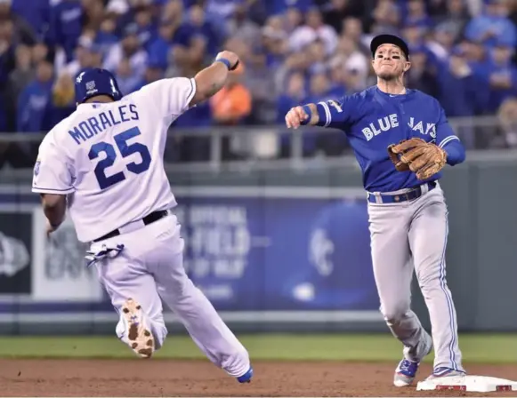  ?? NATHAN DENETTE/THE CANADIAN PRESS ?? The Jays’ middle infield defence shone Friday in Game 1 of the ALCS as Jays shortstop Troy Tulowitzki throws to first to complete a tough double play. Game coverage at thestar.com/sports.