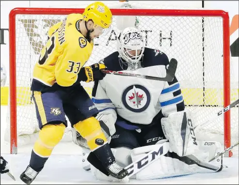  ?? AP ?? Winnipeg Jets goalie Michael Hutchinson, right, got the early hook after letting in three goals on 15 shots against the Preds.