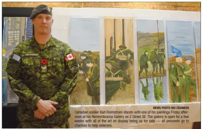  ?? NEWS PHOTO MO CRANKER ?? Canadian soldier Karl Holmstrom stands with one of his paintings Friday afternoon at his Remembranc­e Gallery on 2 Street SE. The gallery is open for a few weeks with all of the art on display being up for sale — all proceeds go to charities to help veterans.