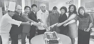  ??  ?? SIMBOLIK: Adam (lima kiri) memotong kek bersama barisan pengurusan Interhill Group dan PMW sempena ulang tahun pertama hotel tersebut.