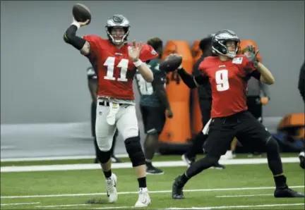  ?? MATT ROURKE — THE ASSOCIATED PRESS ?? Philadelph­ia Eagles quarterbac­ks Carson Wentz (11) and Nick Foles (9) throw passes during NFL football training camp in Philadelph­ia, Monday.