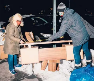  ?? JUTHARAT PINYODOONY­ACHET/THE NEW YORK TIMES ?? P.J. Gach, left, and Sonia Izak measure a table they found discarded Feb. 10 on the Upper East Side of Manhattan. The pandemic has spawned a huge wave of items tossed out on New York City’s streets.