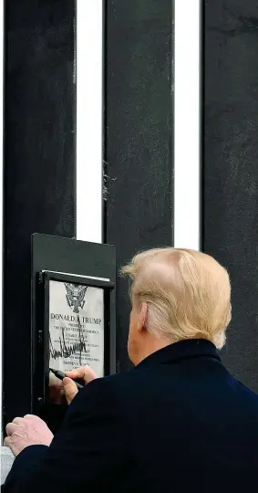  ??  ?? Confini Il presidente Trump firma una targa ad Alamo, in Texas, affissa sul Muro da lui voluto
