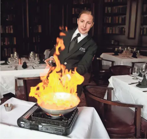  ?? MIKE DE SISTI / MILWAUKEE JOURNAL SENTINEL ?? Erika Dralle, a dining room captain, prepares bananas Foster tableside at Rare, a downtown steakhouse.