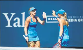  ?? Michael Cummo / Hearst Connecticu­t Media ?? Partners Kiki Bertens, left, and Johanna Larsson high-five after winning a point during a first-round doubles match against Monique Adamczak and Oksana Kalashniko­va at the Connecticu­t Open in New Haven Wednesday. Bertens and Larsson won 6-3, 6-4.
