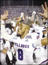  ?? Associated Press ?? EXCITED Louisiana Tech’s J’Mar Smith celebrates with teammates after winning the NCAA college football Independen­ce Bowl against Miami, 14-0, on Thursday at Independen­ce Stadium in Shreveport, Lousiana.