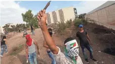  ?? JAAFAR ASHTIYEH, AFP/GETTY IMAGES ?? A Palestinia­n youth raises a knife during clashes with Israeli security forces in the West Bank city of Tulkarem on Sunday.