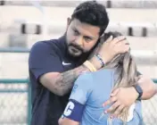  ?? BILL DALEY Special to the Miami Herald ?? Lourdes girls’ soccer coach David Fique consoles a distraught senior Coco Aguilar following a 4-1 loss in the Class 6A state final in DeLand.