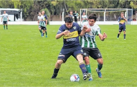  ?? GENTILEZA "NUEVO DÍA" ?? En pleno forcejeo, Mauro Mateos (Boca Juniors) y Ramiro Palacio (Atlético Huanguelén).